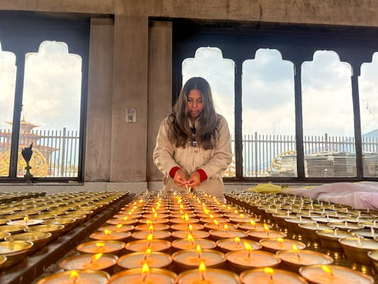 Lighting 108 butter lamps Bhutan